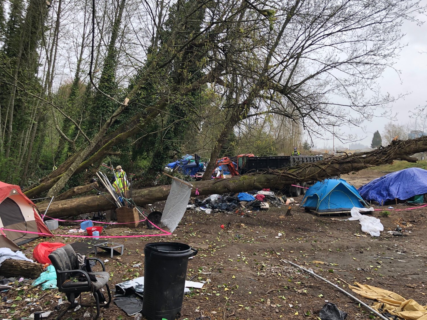 Workers from Advance Environmental used rakes and shovels to gather the debris at the homeless encampment on Deschutes Parkway on Day 1 of the cleanup project that started Wed., April 7, 2021.