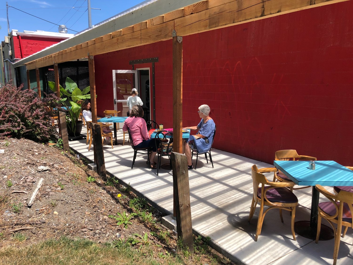 The new patio at New Traditions Cafe has a full-width cover for three-season dining. Getting re-acquainted are (l-r) old friends Imani Etile, Kolea Quincey and Marjorie Rehbach.