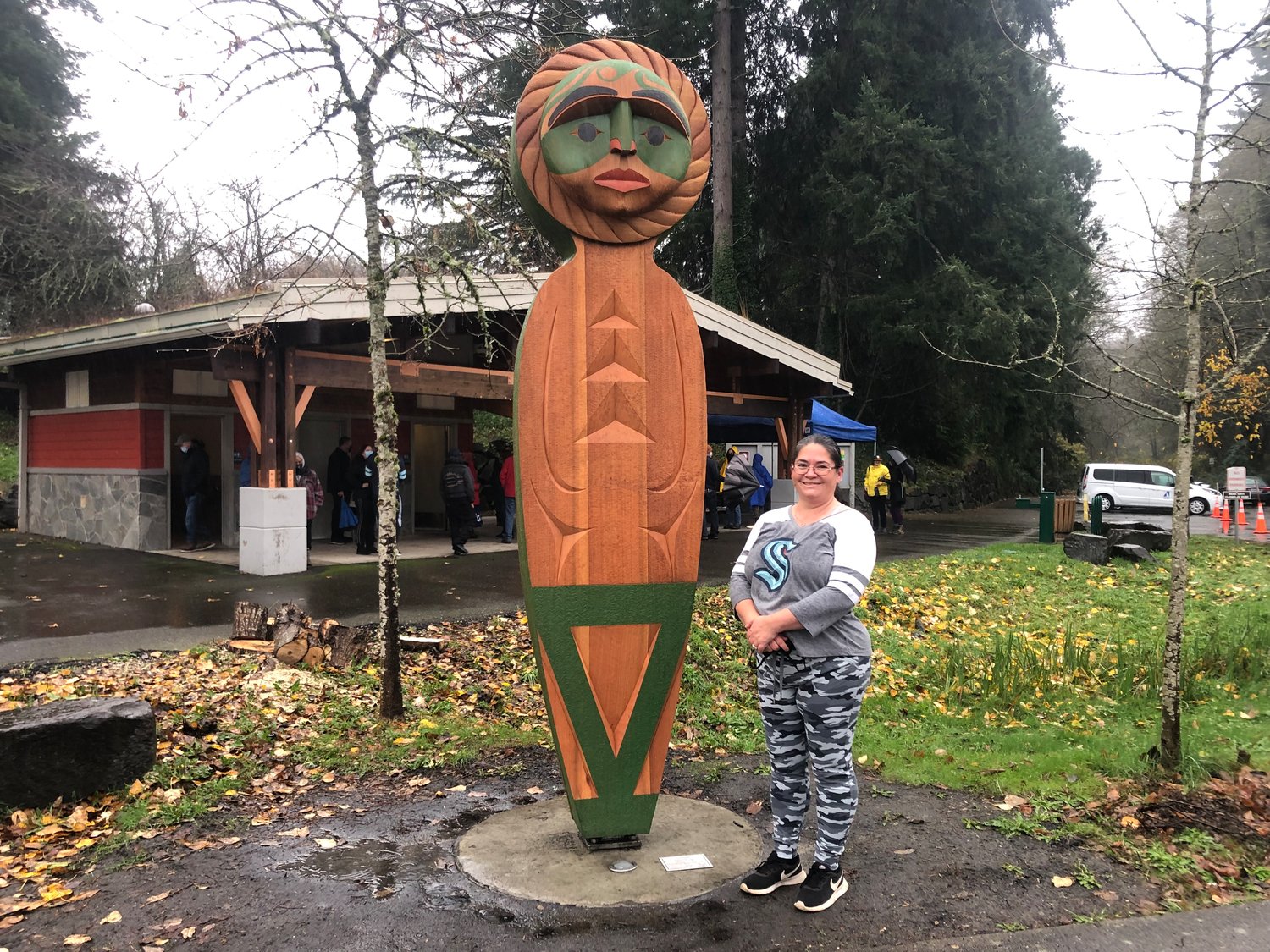 Andrea Wilbur-Sigo, the Squaxin Island Tribe carver, stands next to "People of the Water," half of the Unity project installed on Eastside Street in Olympia, on Dec. 11, 2021.