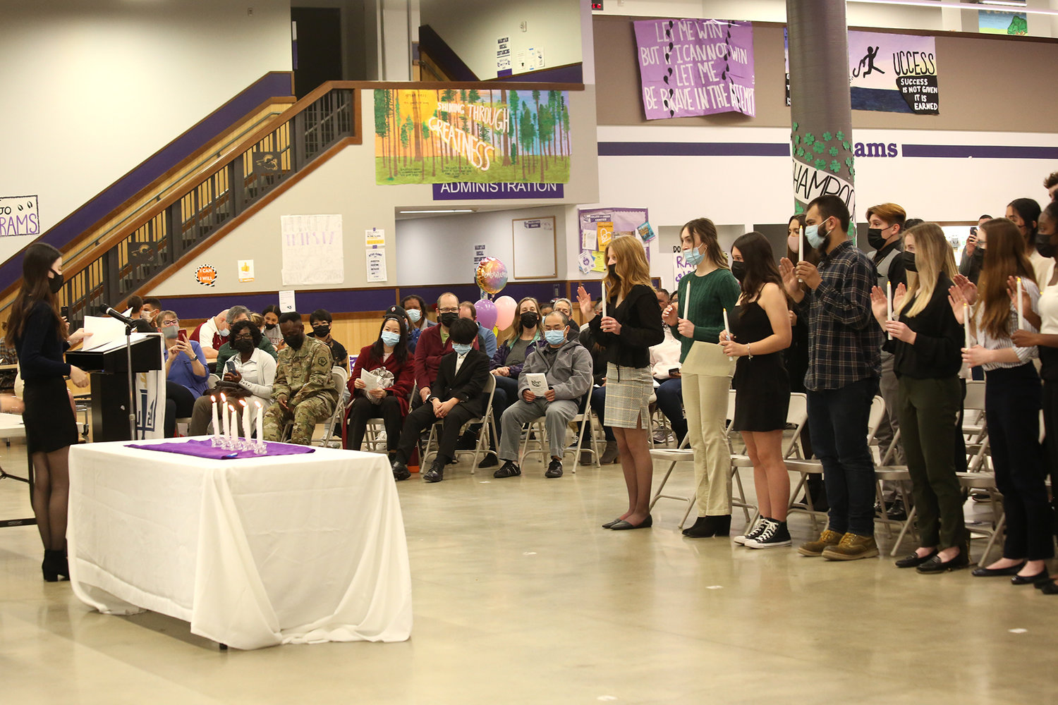 Parents of the inductees, seated on the left, watch on as their children are inducted by a National Honor Society officer.