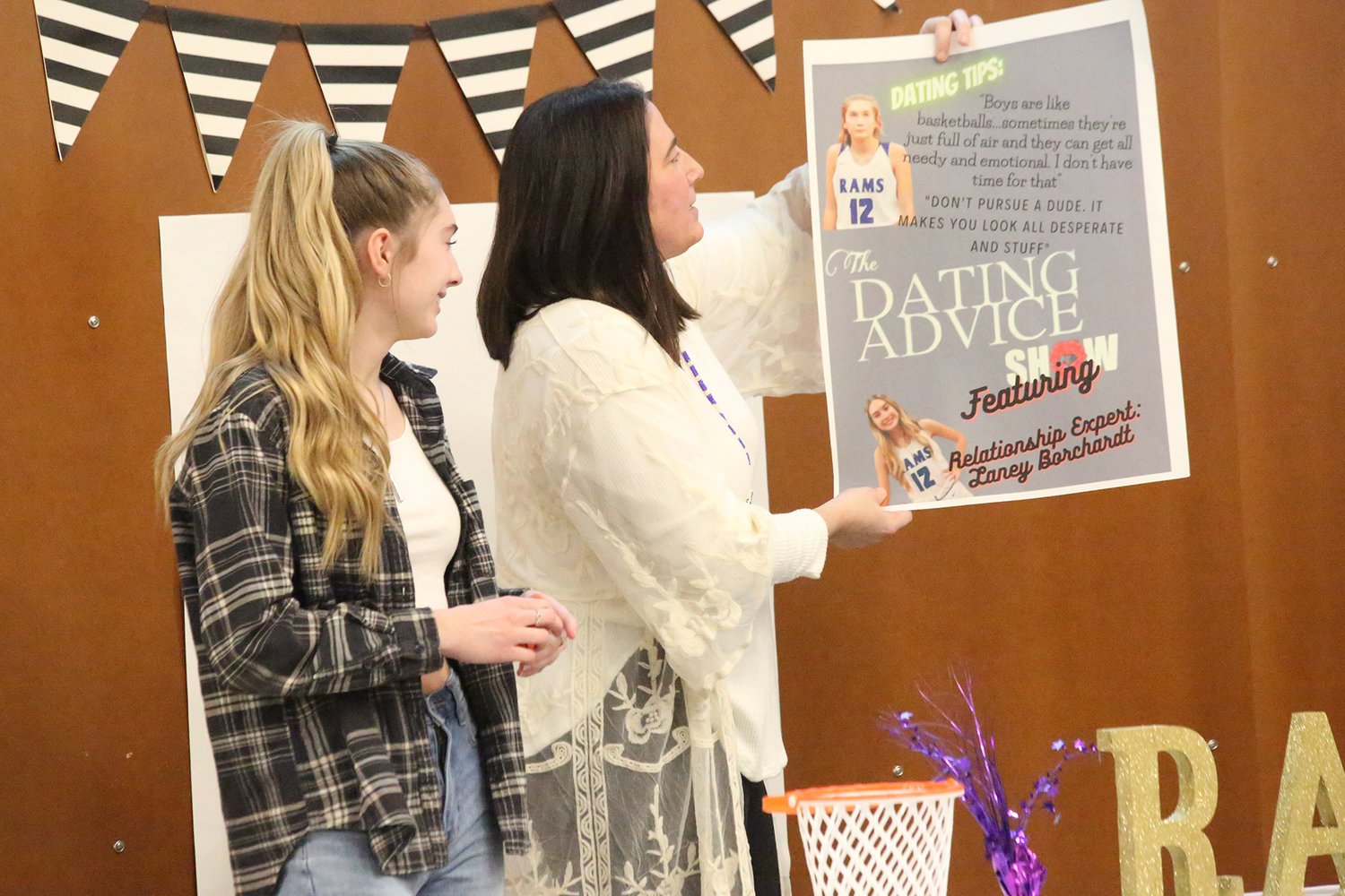 Lady Ram Laney Borchard looks on as Coach Jackie Meyer admires the poster the team made for her.