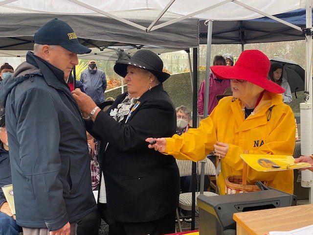 ] Ron Frederick, at the Vietnam Veterans Memorial in Olympia, is pinned by Regent Janell Crumpacker of the Sacajawea Chapter, DAR. The Vietnam War 50th Commemoration lapel pins are presented to vets as a gesture of national thanks, 11-11-2021.