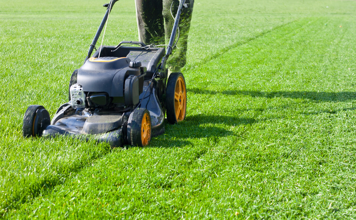 Lawn mower being used to trim a large area of grass