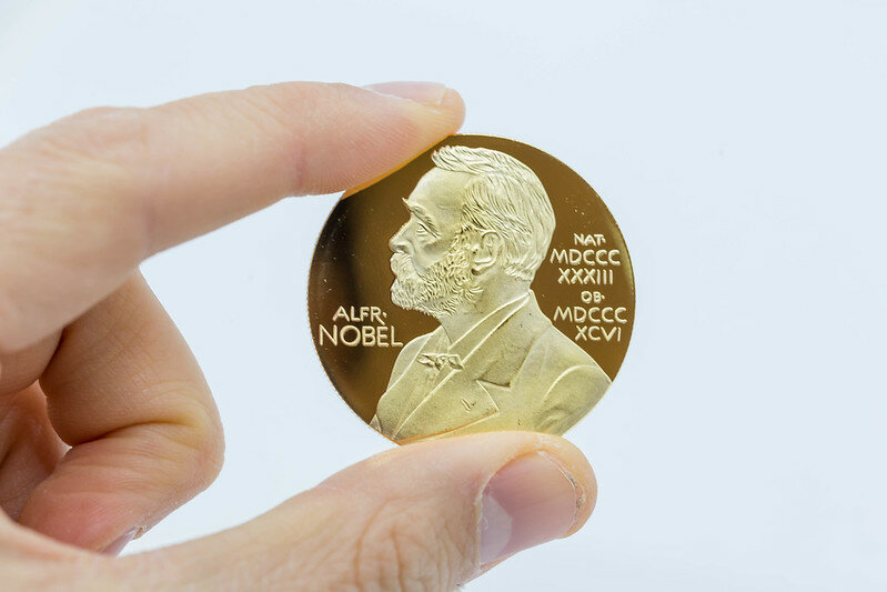A hand holding a Nobel prize